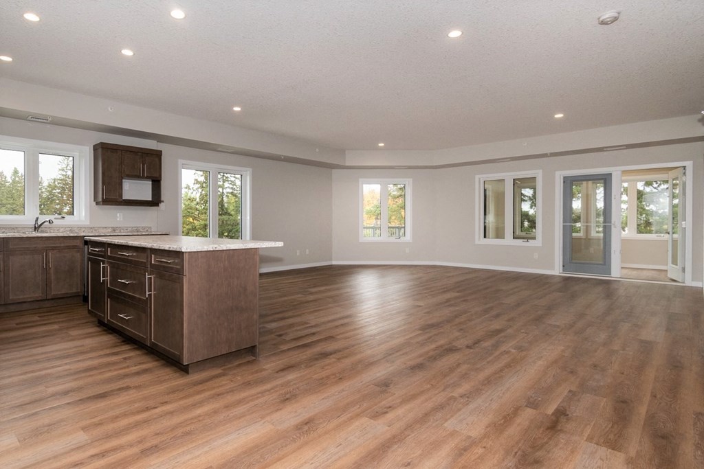 the kitchen and living room of a new home with wood flooring