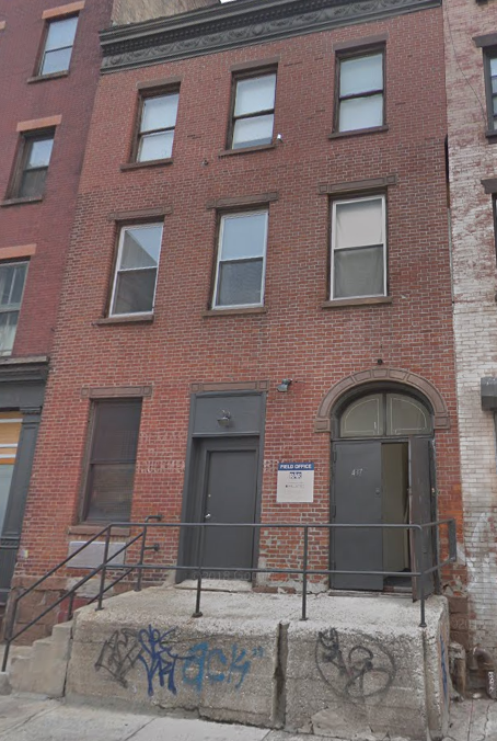 the front of a brick building with a black door