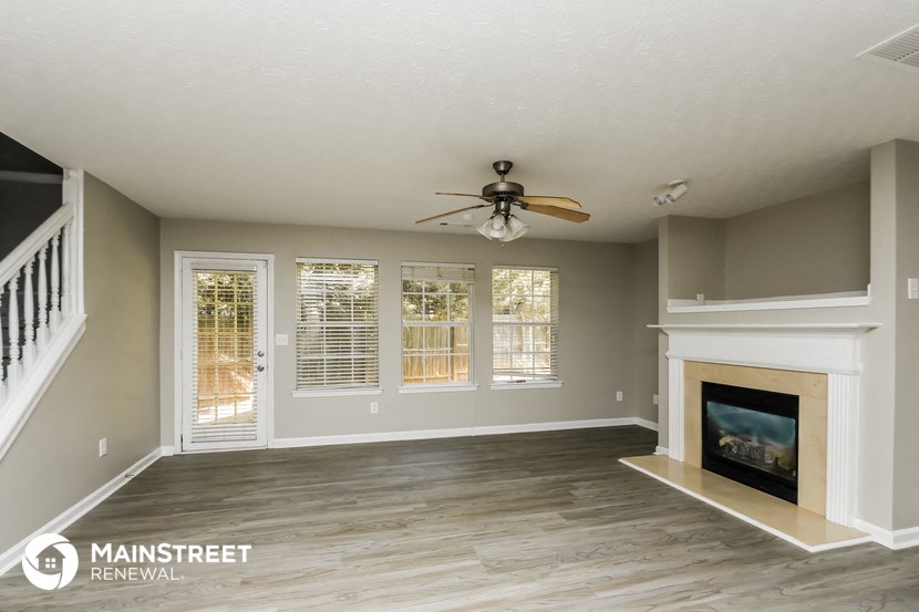 a living room with a fireplace and a ceiling fan