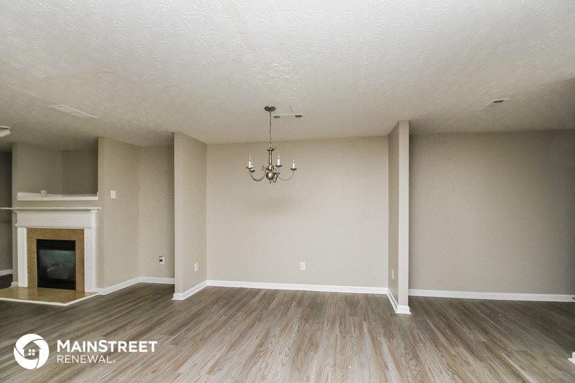 the spacious living room with fireplace and wood flooring