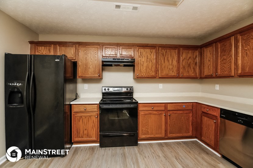 a kitchen with black appliances and wooden cabinets
