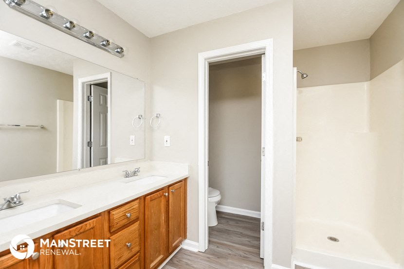 a bathroom with a large mirror and a sink and a toilet