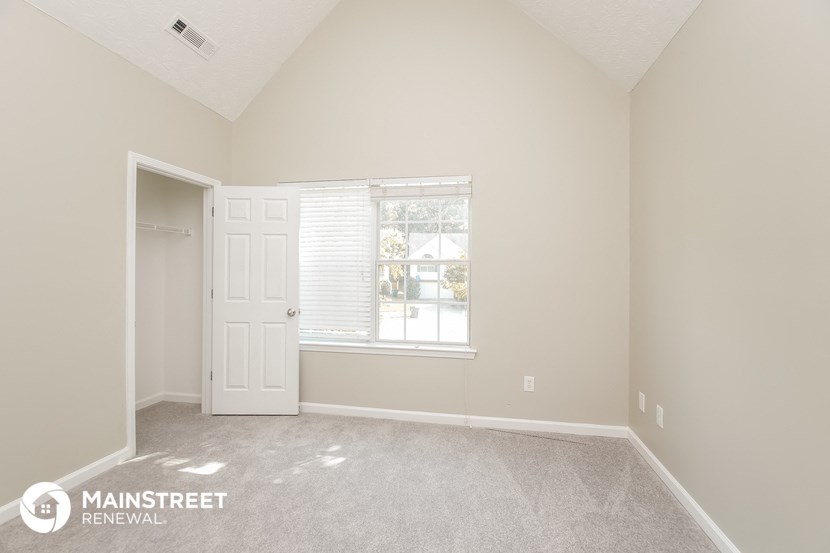 a bedroom with a white door and a window