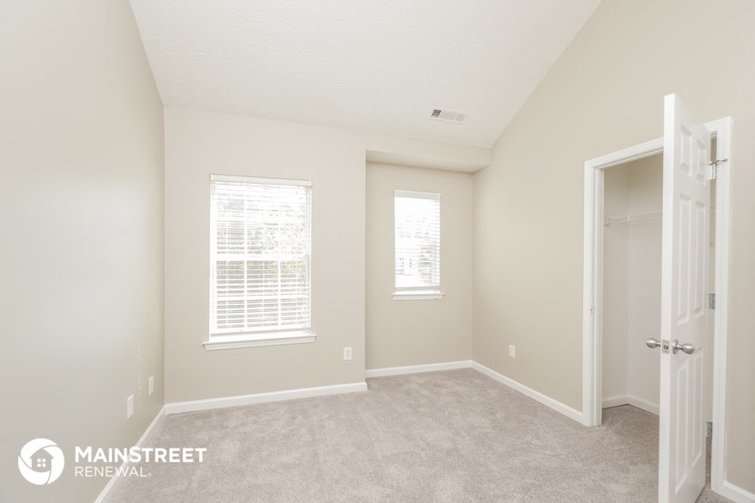 a spacious bedroom with a closet and a door to the bathroom