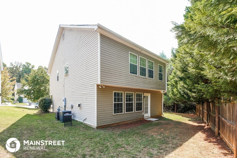 the back of a house with a yard and a fence