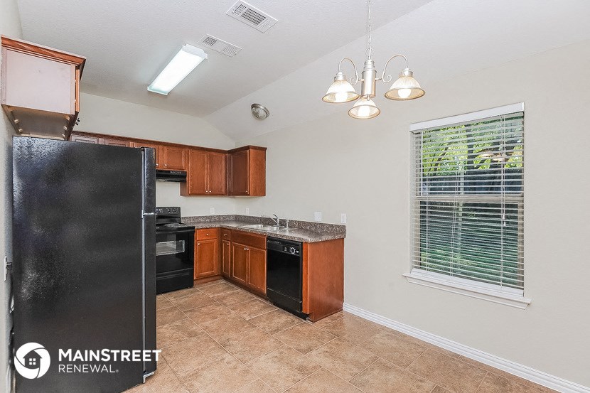 a kitchen with a black refrigerator and a window