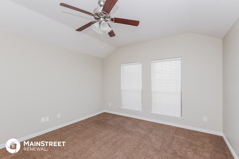 the living room of a home with a ceiling fan