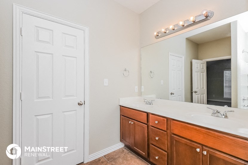a bathroom with two sinks and a large mirror