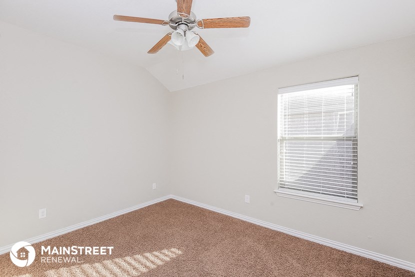 the bedroom has a ceiling fan and a window