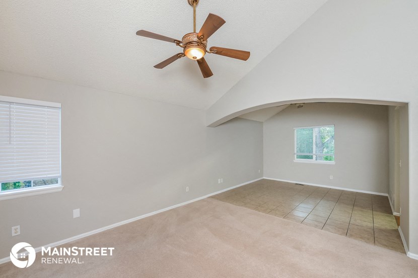 the living room and dining room with a ceiling fan