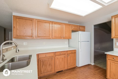 a kitchen with wooden cabinets and a sink and a refrigerator
