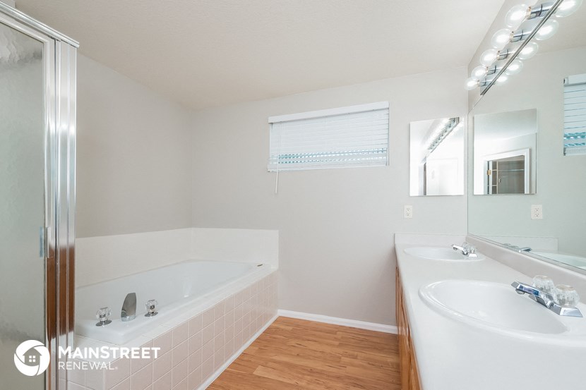 a bathroom with a tub and a sink and a mirror