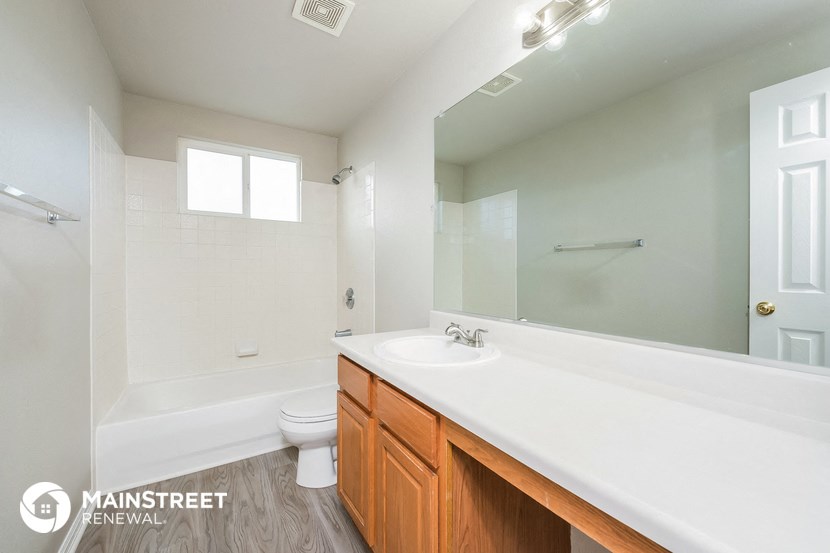a bathroom with a large mirror and a sink and a toilet
