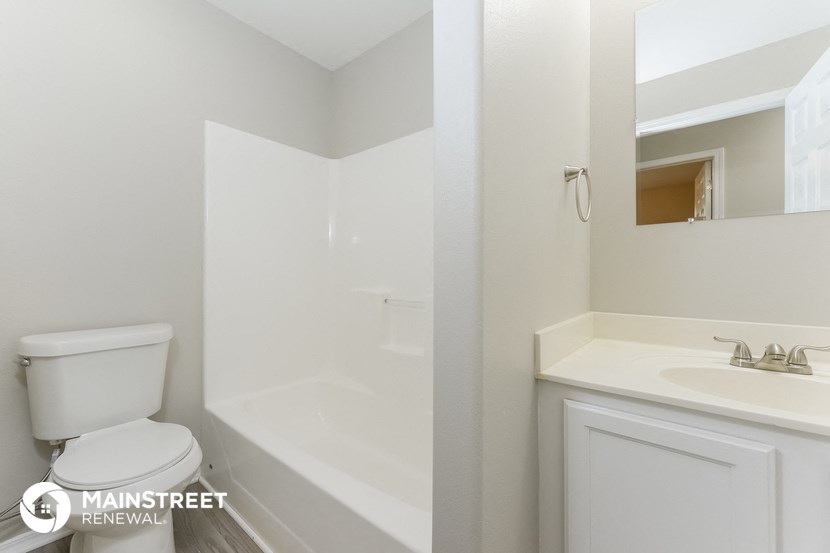 a bathroom with a toilet and a sink and a bath tub