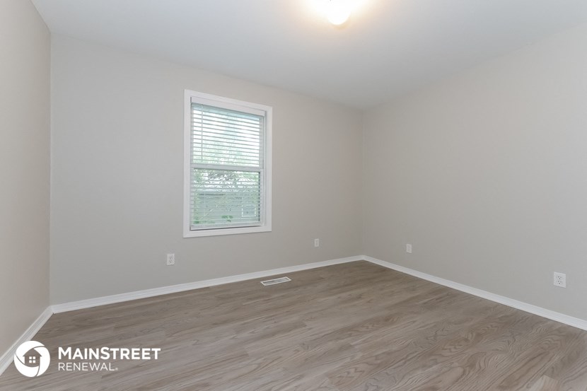 the interior of an empty room with wooden floors and a window