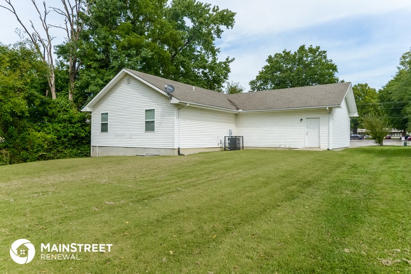 the front of the house with a large yard and a white house