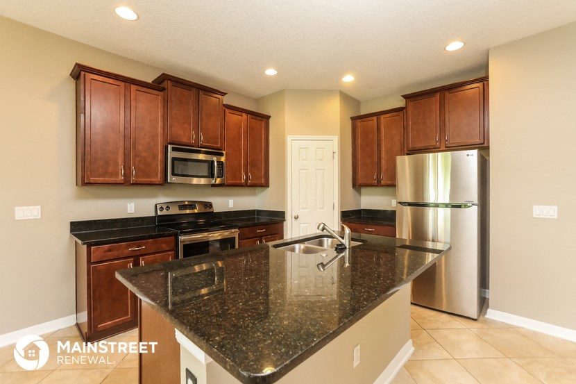 an updated kitchen with granite countertops and stainless steel appliances