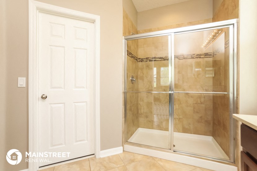 a bathroom with a shower and a white door