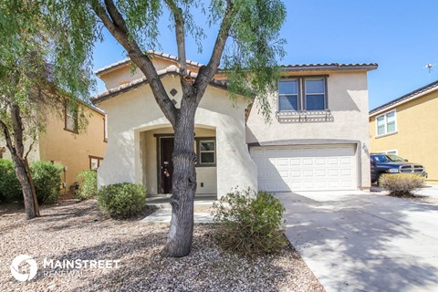 a house with a garage and a tree in front of it