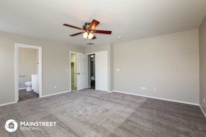 a living room with carpet and a ceiling fan