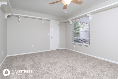 the living room of a manufactured home with carpet and a ceiling fan