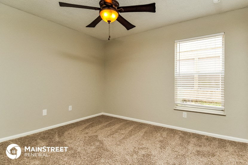 the master bedroom has a ceiling fan and a window