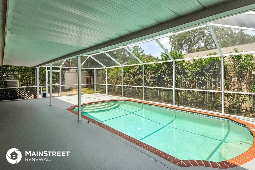 a large swimming pool in a house with a glassed in porch