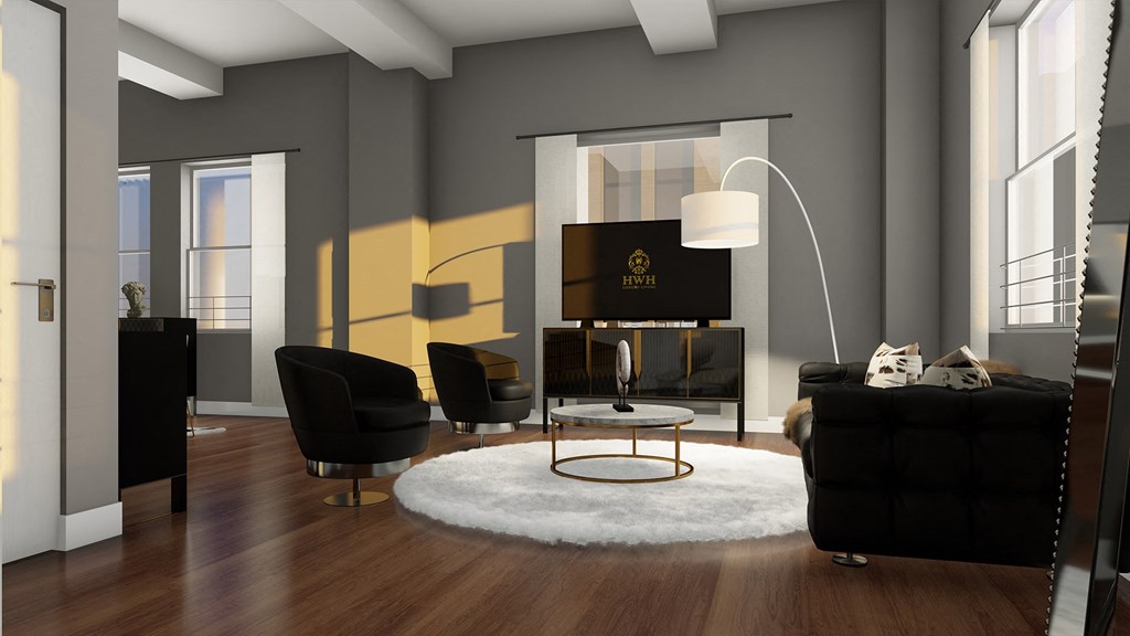 a living room with black furniture and a white rug