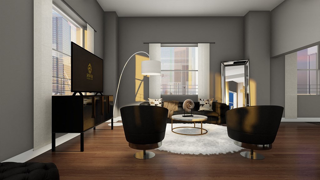 a living room with black furniture and a white rug