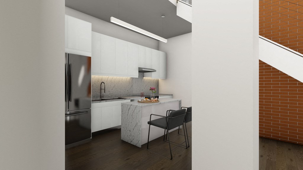 a kitchen with white cabinets and a marble counter top and a stainless steel refrigerator