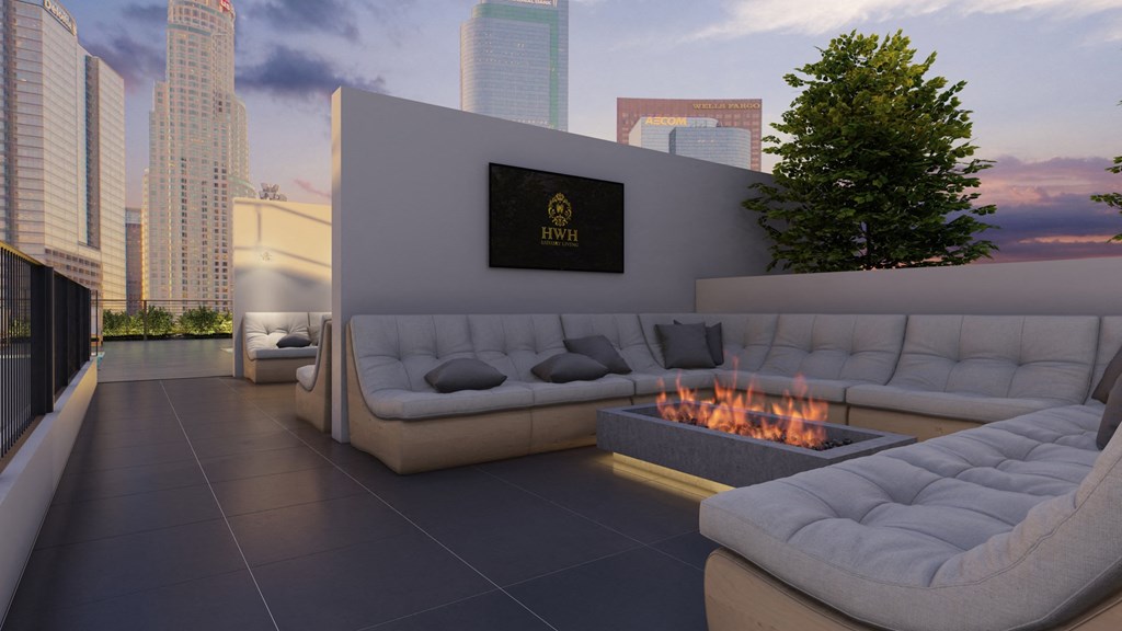 a rooftop lounge area with couches and a fire pit