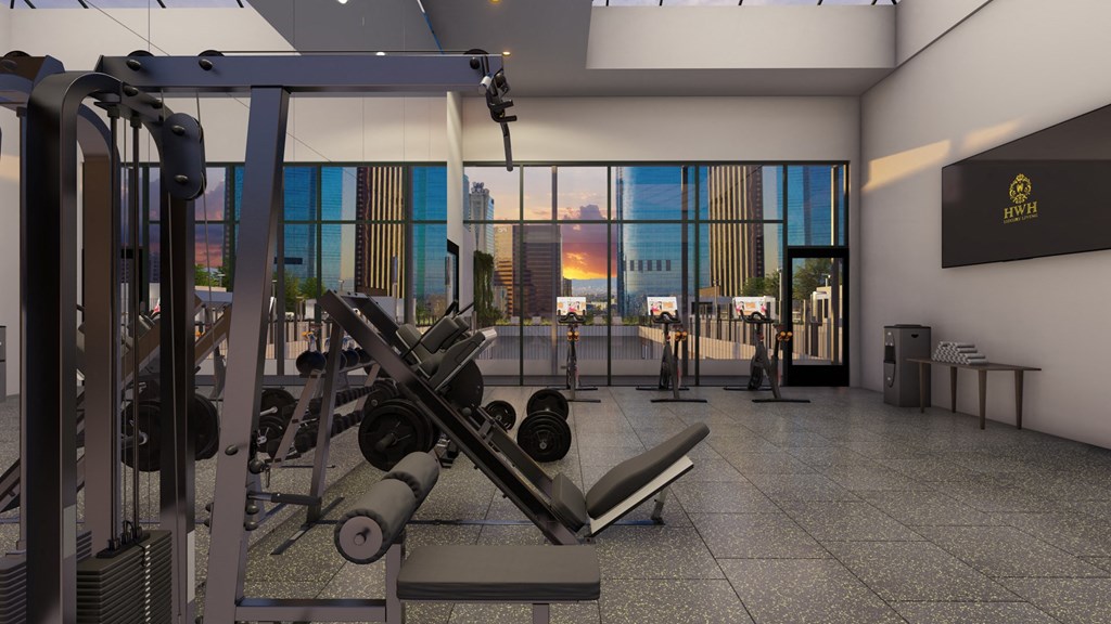 a workout room with weights machines and a view of the city