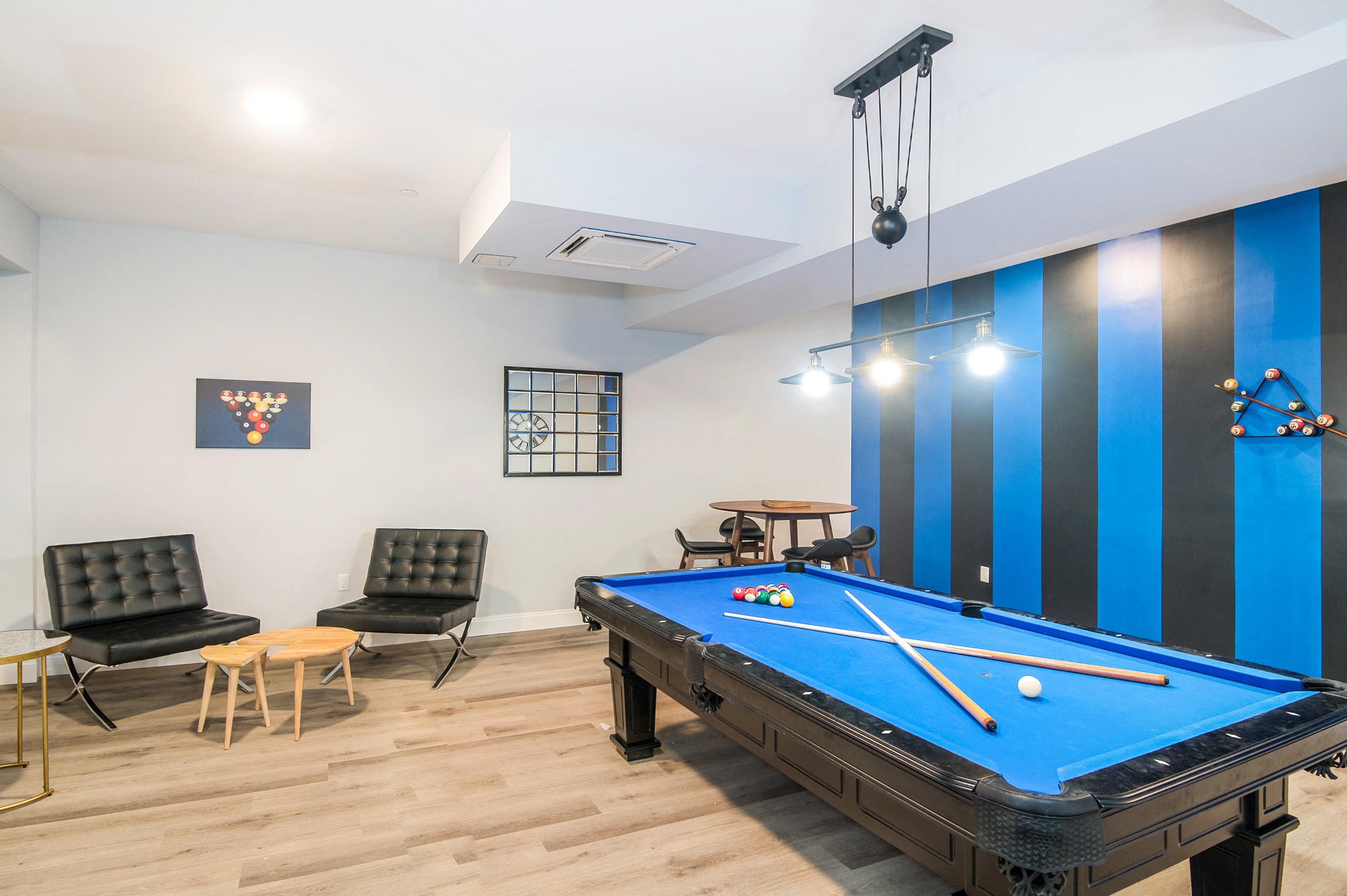a games room with a pool table and chairs