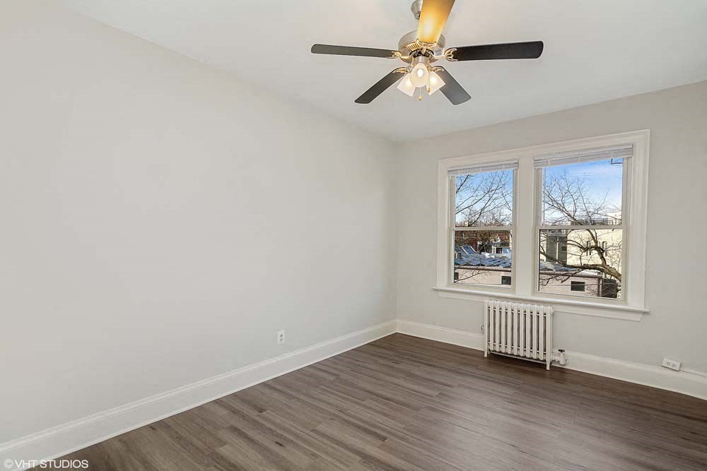 a bedroom with a ceiling fan and a window