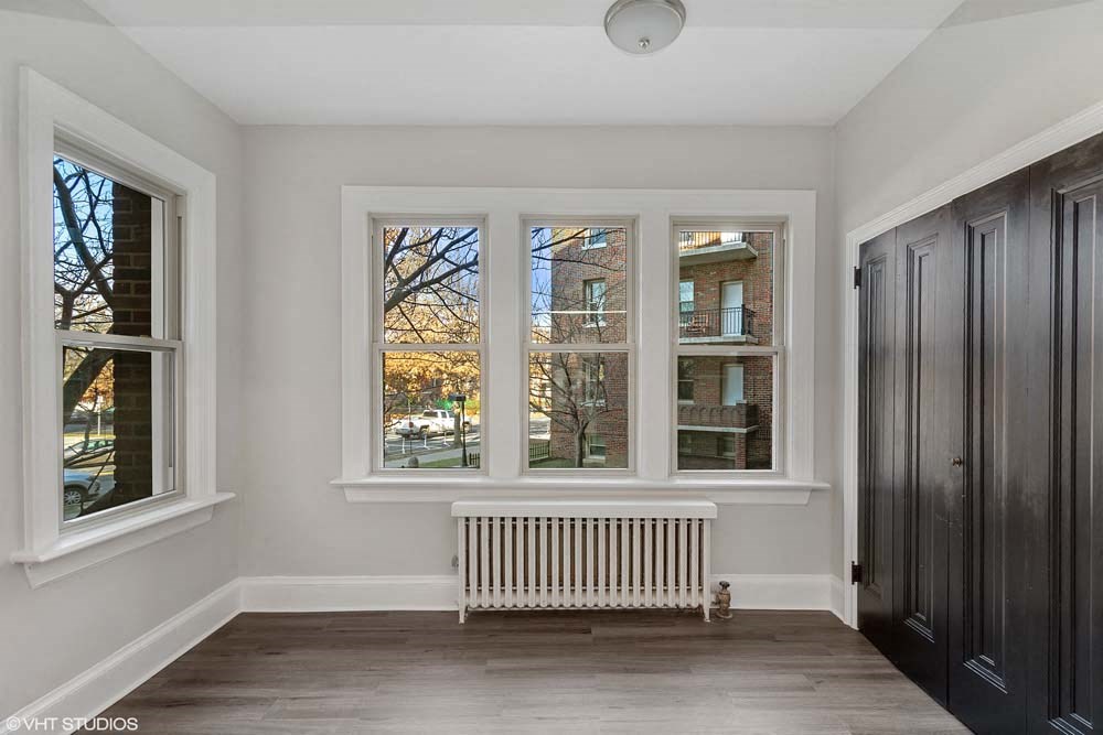 an empty room with four windows and a radiator