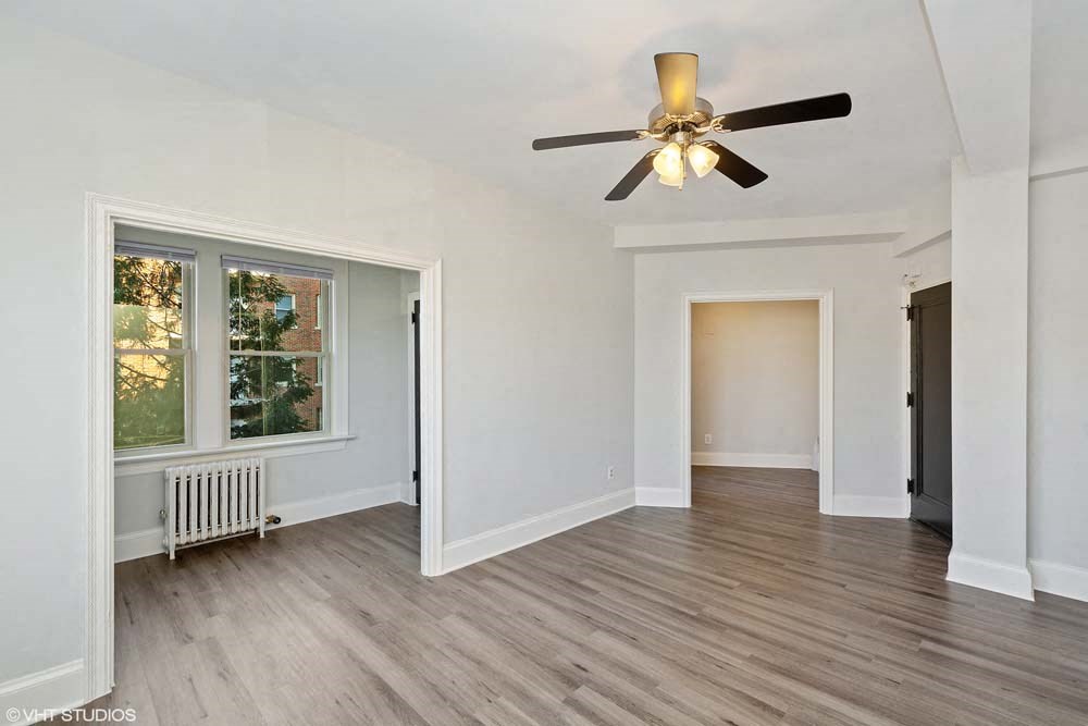 a living room with hardwood floors and a ceiling fan