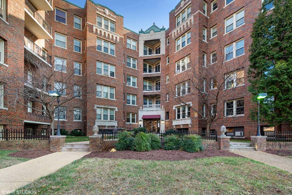 a large brick building with a grassy area in front of it