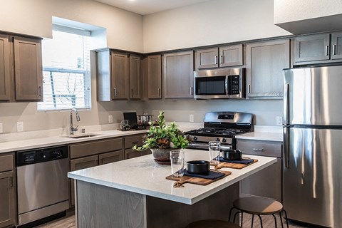 a kitchen with stainless steel appliances and a marble counter top