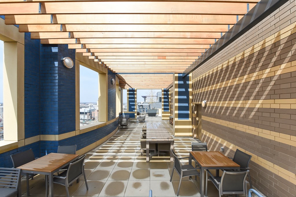 a dining area with tables and chairs and a brick wall with wooden ceilings