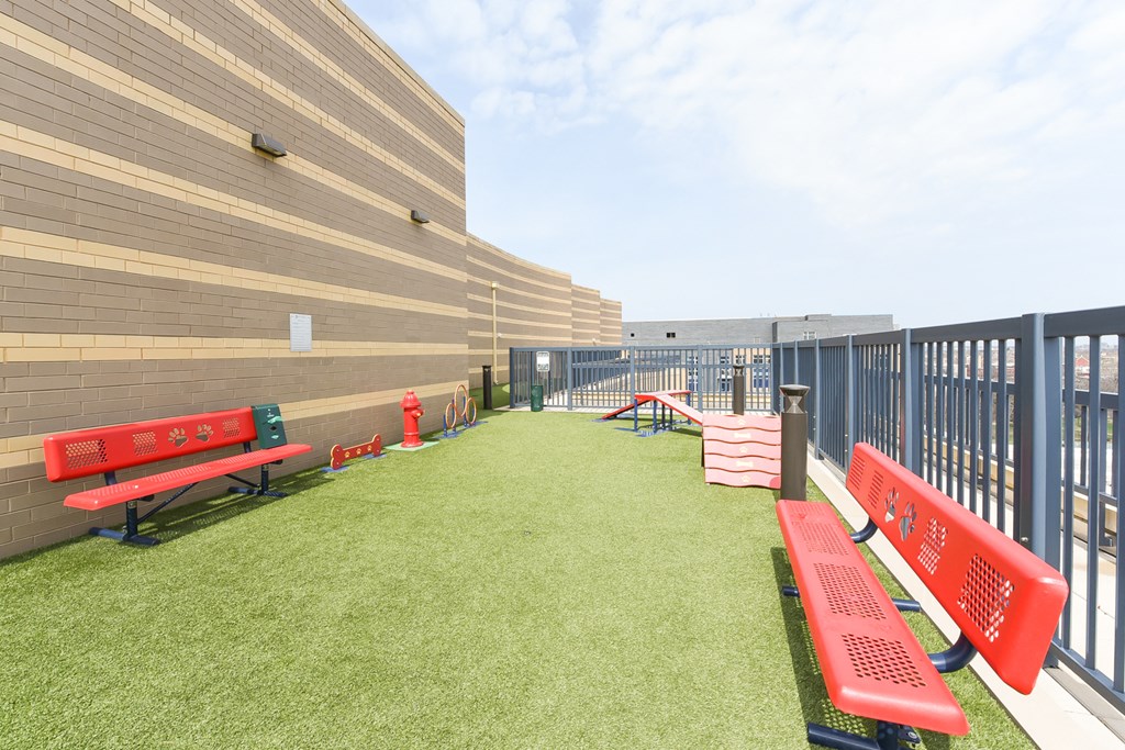 a grassy area with benches and a fence