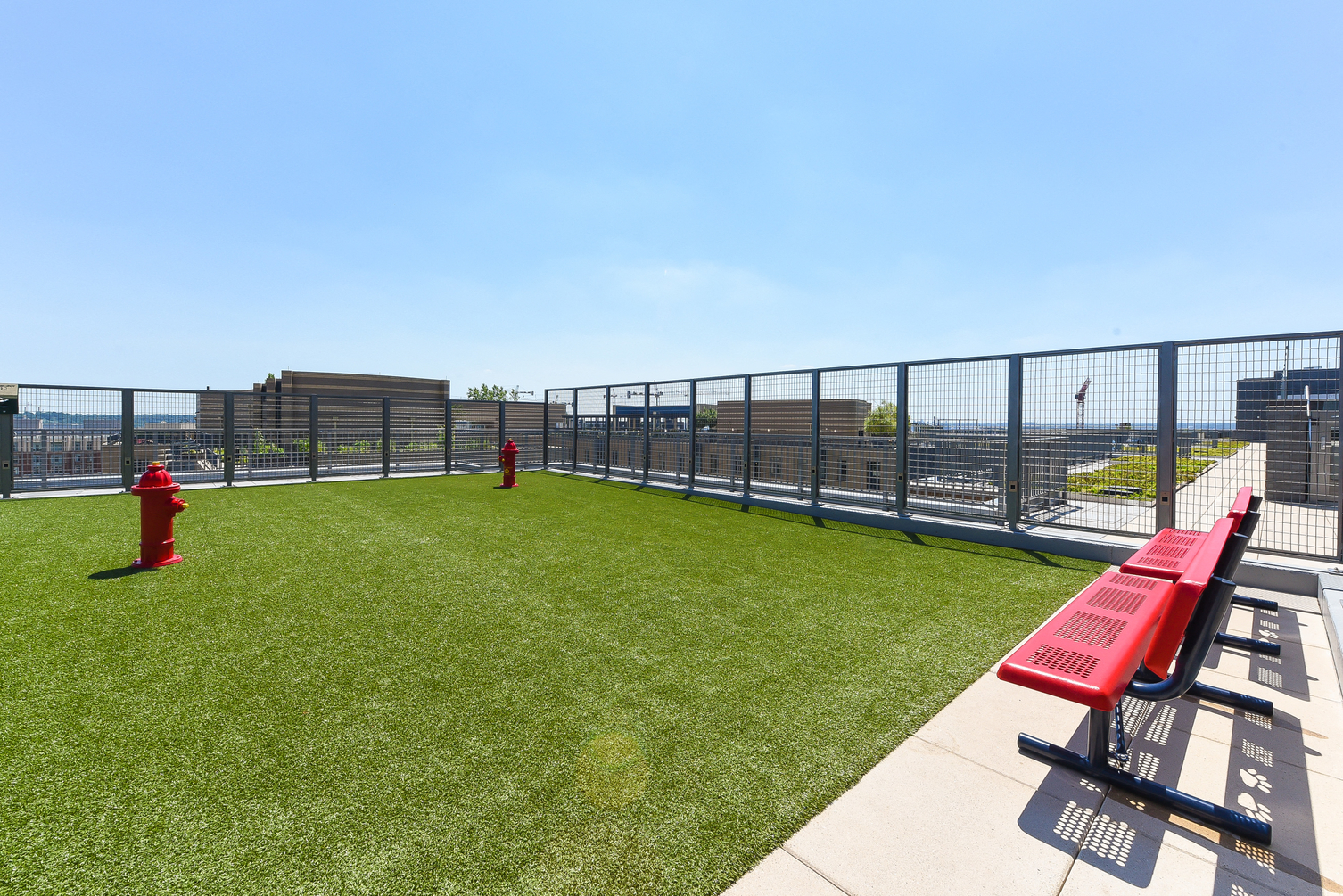 a grassy area on the roof of a building with a red bench
