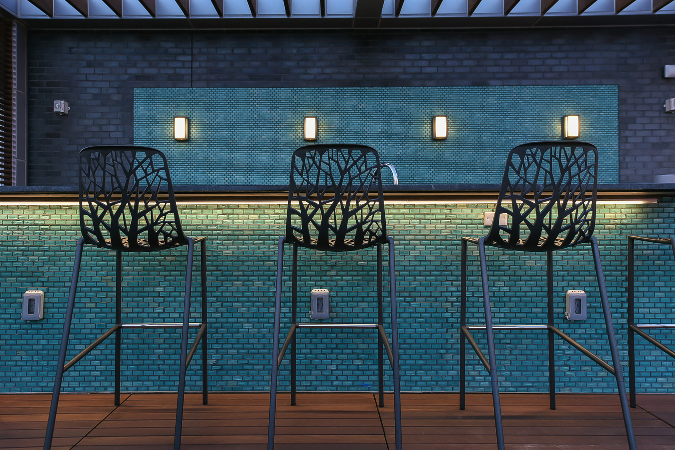 a row of chairs in front of a blue brick wall