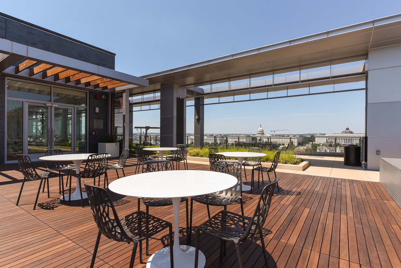 an outdoor patio with tables and chairs on top of a building