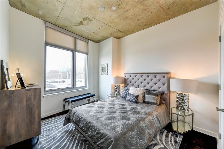 a bedroom with a bed and a large window