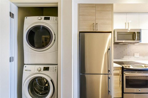 a kitchen with a washing machine and a refrigerator