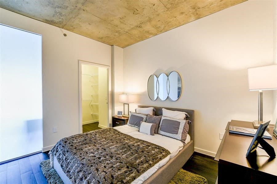 a bedroom with a bed and two mirrors on the wall