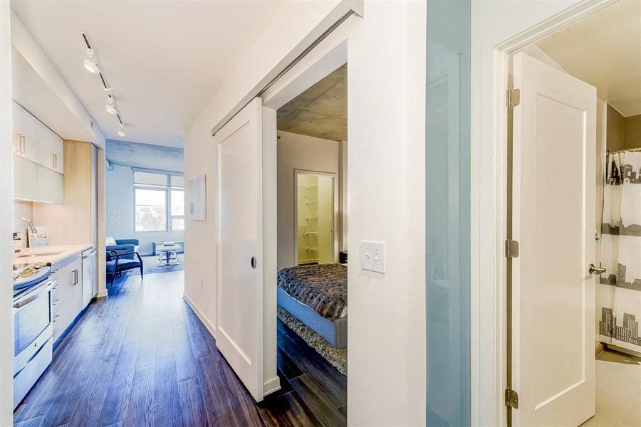 a room with a bed and a kitchen in it