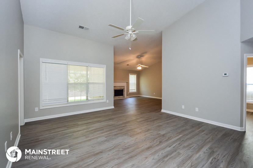 the living room and dining room of an empty house