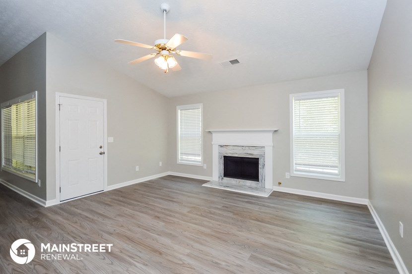 the living room with fireplace and ceiling fan