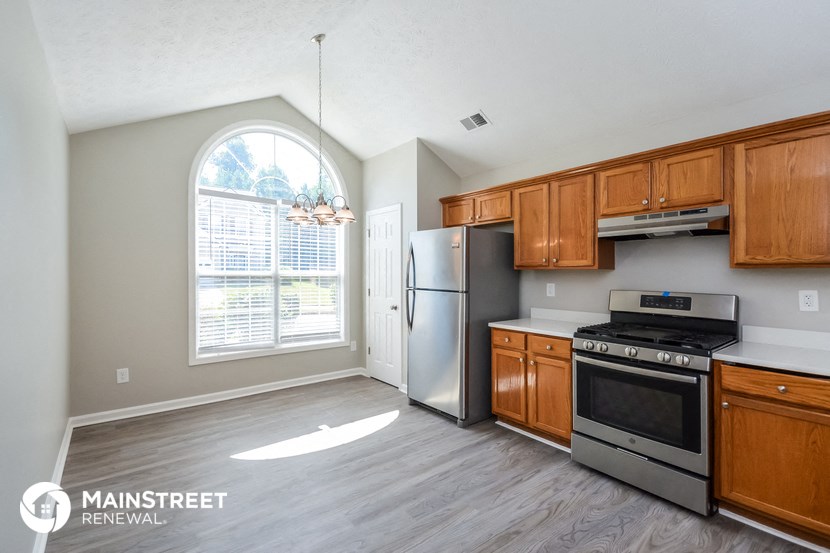 an empty kitchen with wooden cabinets and stainless steel appliances